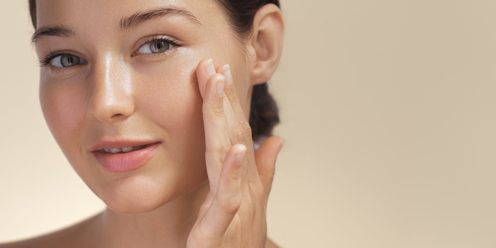 Femme appliquant un soin hydratant éclatant au visage, peau lumineuse et nette