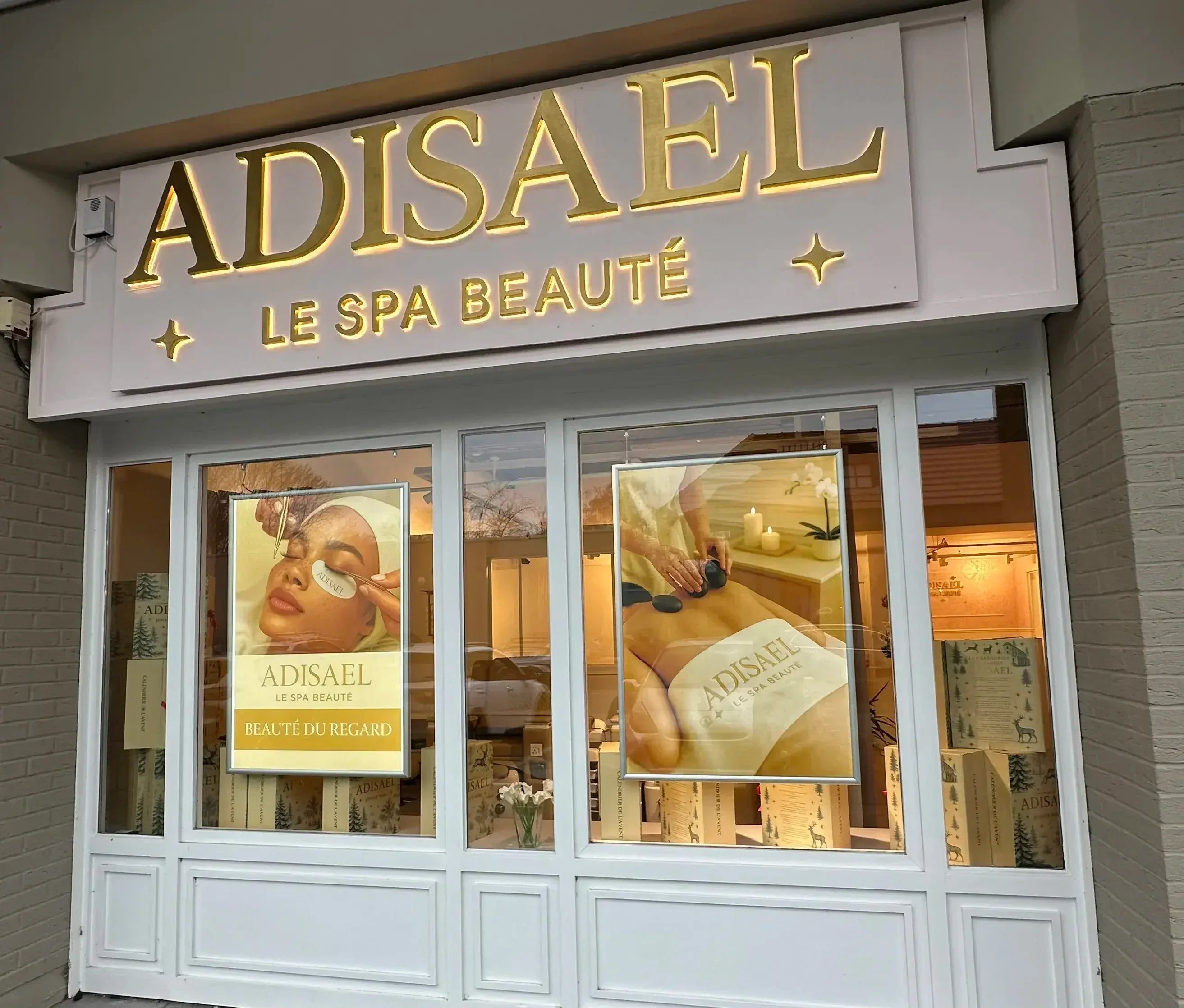 Façade du spa beauté ADISAEL avec enseigne lumineuse et affiches soins visage et massage
